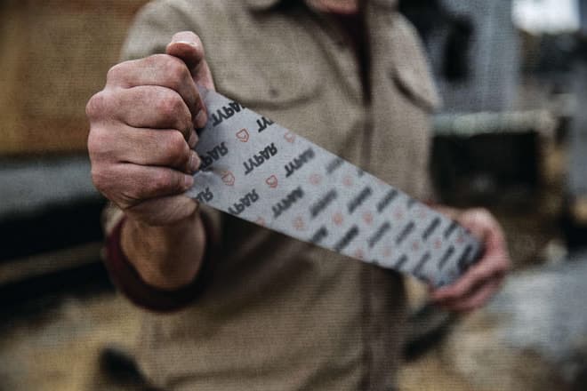 Man unwraps TYPAR Construction Tape