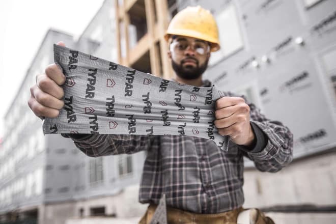 Construction worker show stretch of TYPAR Flexible Flashing product
